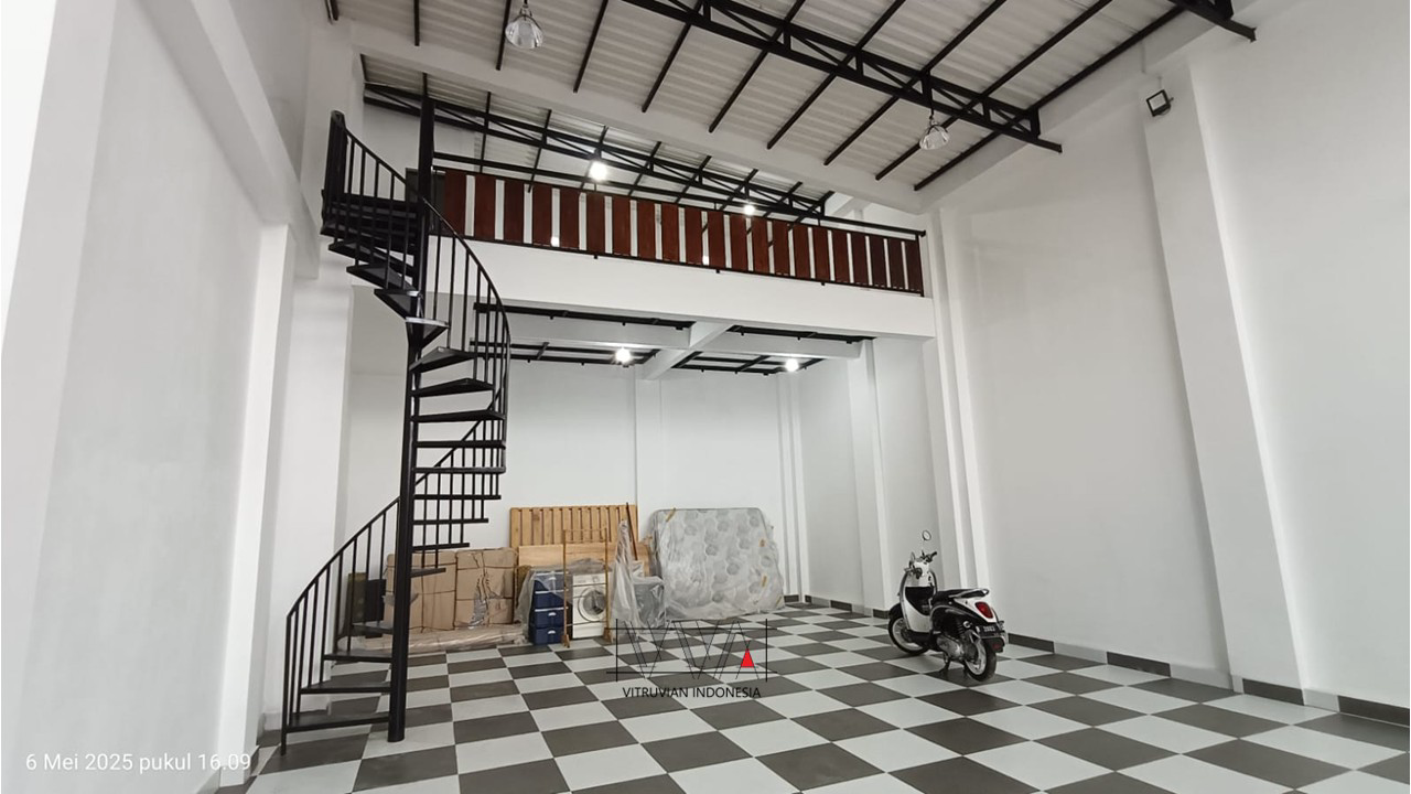 Interior garasi 9 mobil dengan mezanin dan tangga putar sebagai akses menuju ruang bersama.